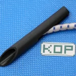 Close-up of a black, conical plastic nozzle with a cylindrical shape on a blue textured surface, next to a piece of white and blue braided rope and a label with the text 'KOP', which are part of the 8″ Scaffold Bungees and 12″ Scaffold Bungees set.