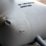 Close-up view of a large, gray Cube collapsible water tank with round corner reinforcement, featuring multiple ring loops and a visible size and capacity label specifying "1.0m x 1.0m x 0.5m" and "300L.