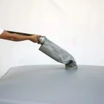 Person attaches a gray hose to the Cube collapsible water tank with round corner reinforced.