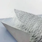 A Double Wall Fabric, Drop Stitch Tarpaulin stands folded on a flat surface, with numerous white filaments extending from one side, creating a textured, fringe-like appearance.