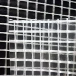 Close-up image of a checkered pattern created by overlapping white FR SCAFFOLD SHEETING-10oz fabric on a black background.