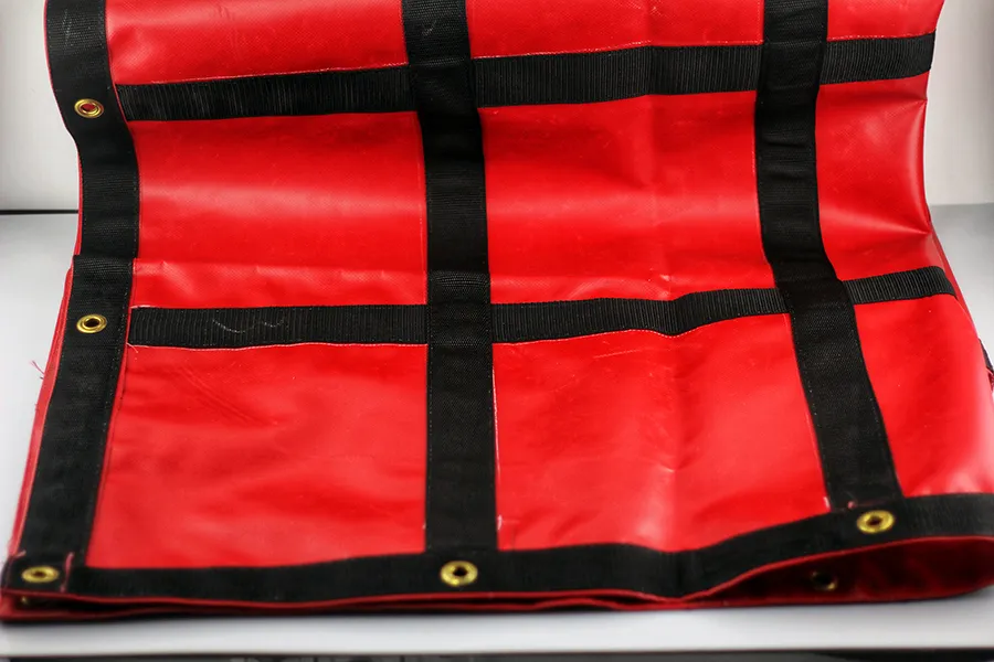A red Lumber Tarp with Flap for Flatbed Truck and Trailer – 8′ Drop, featuring black stripes and brass grommets.